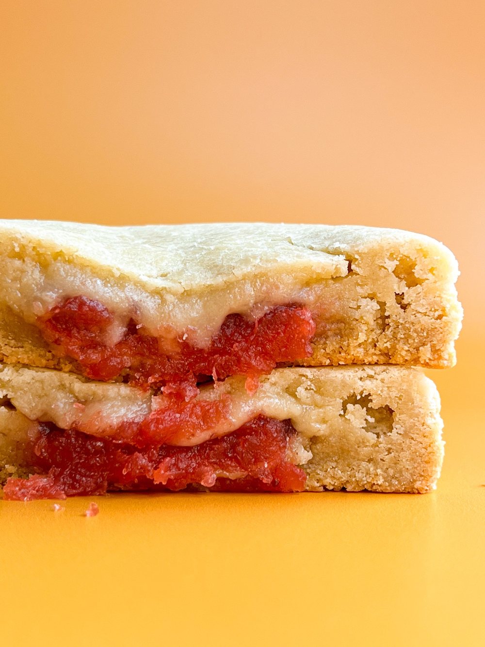 A stuffed cookie, cut in half, showing the fruit filling layered inside