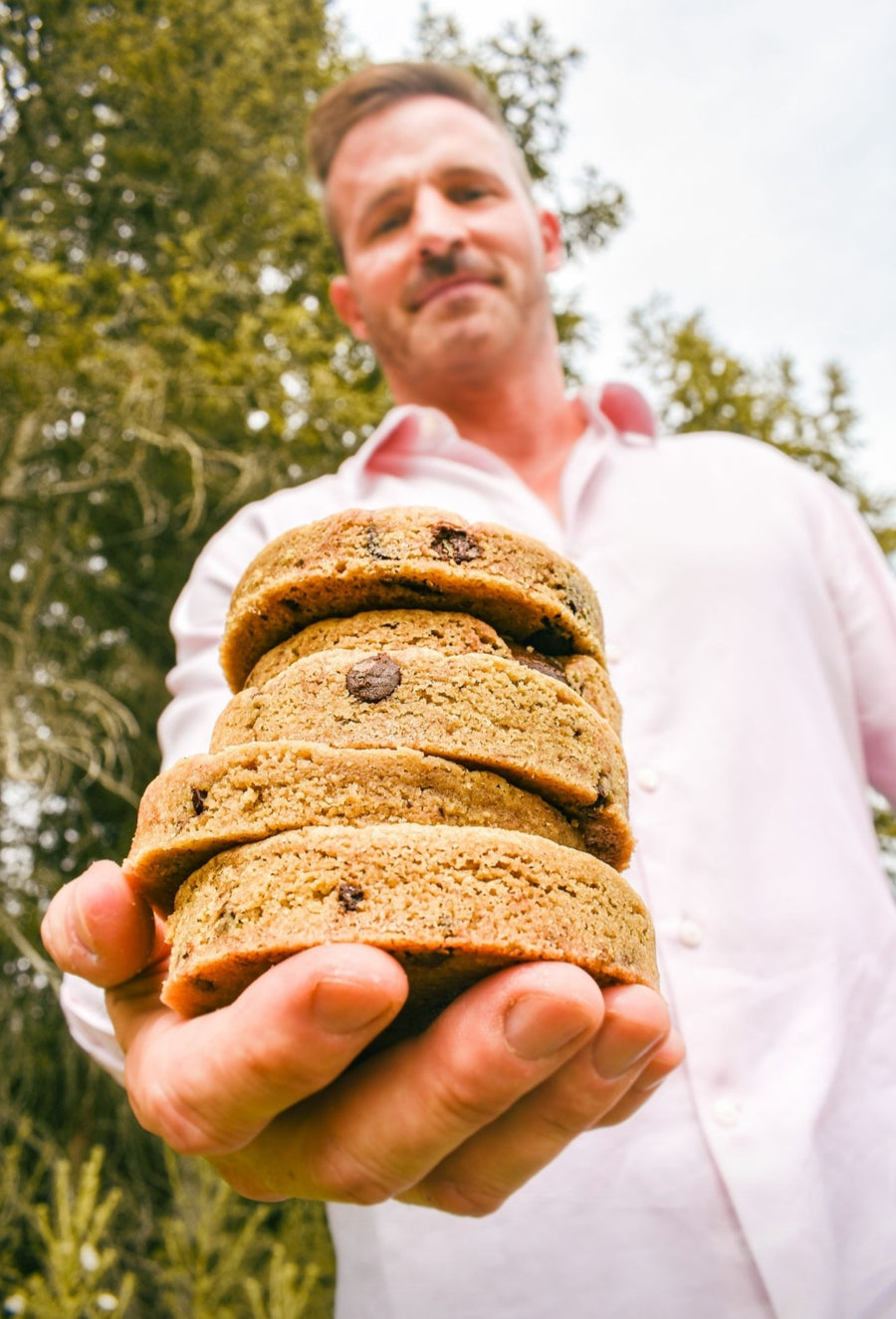 Nick Freed holding a stack of his stuffed cookies out toward the camera