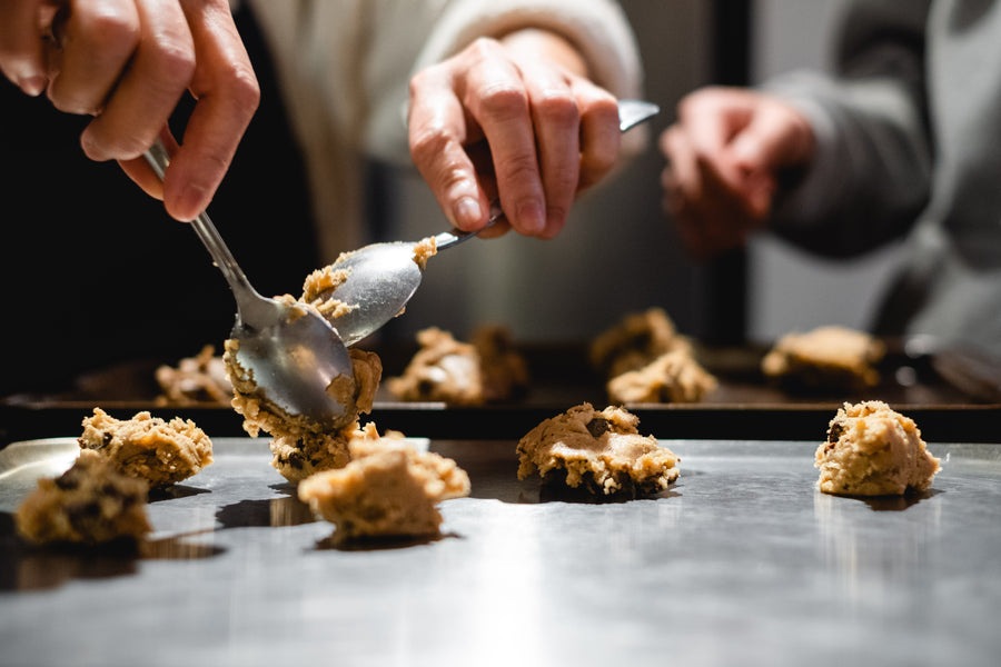 Cookie dough being scooped onto a baking sheet in the bakery
