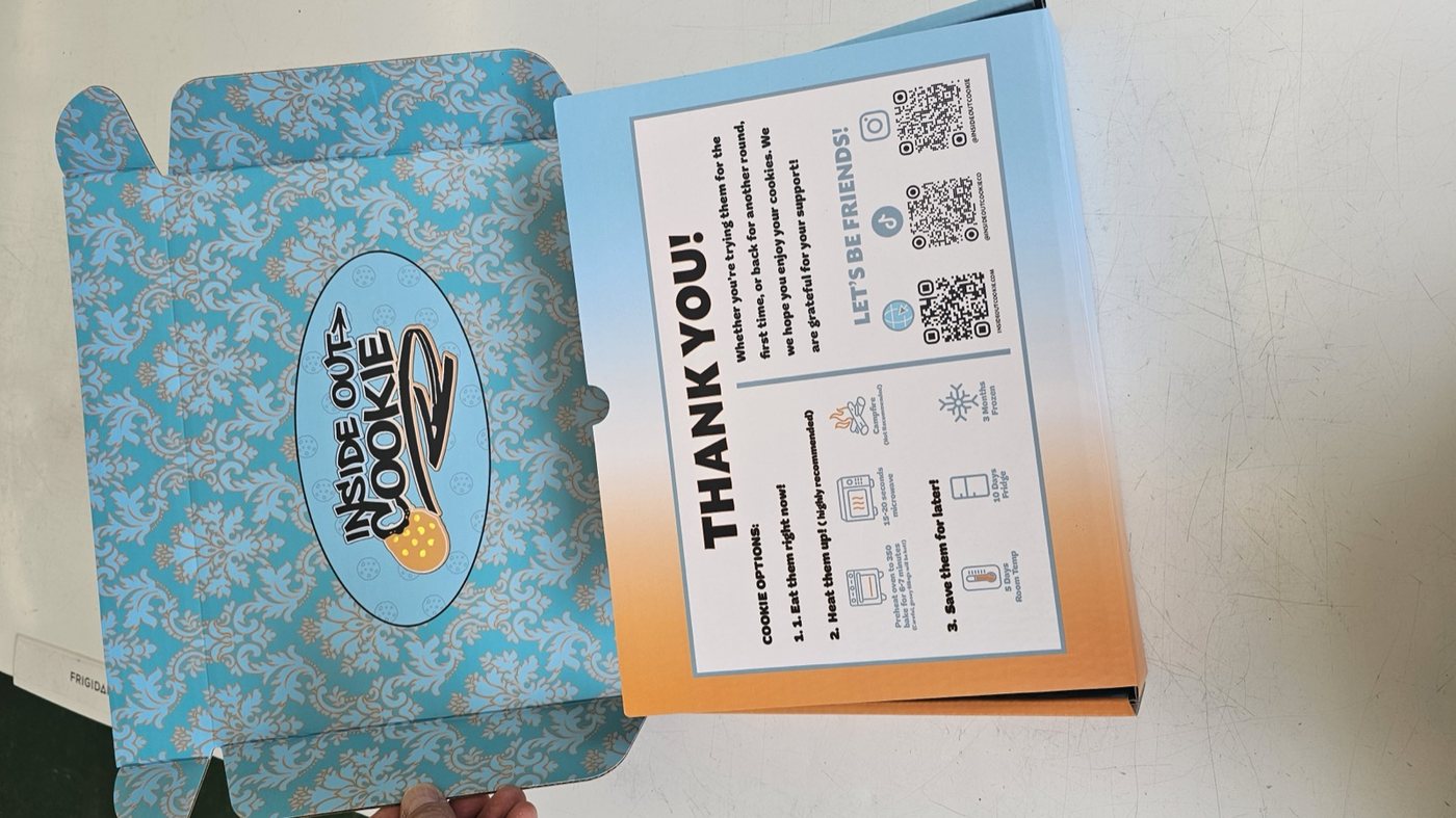 An open Inside Out Cookie box showing the damask interior and the heating card in the lid